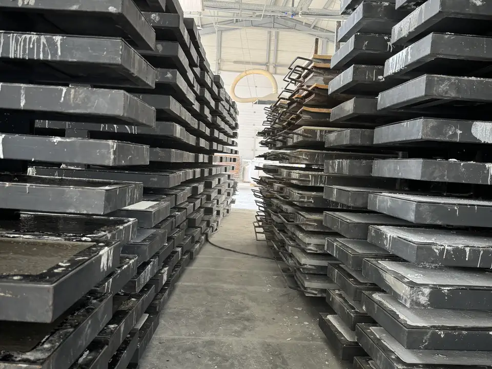 Stapel von Stahlformen für Zaunplatten in der Produktionshalle